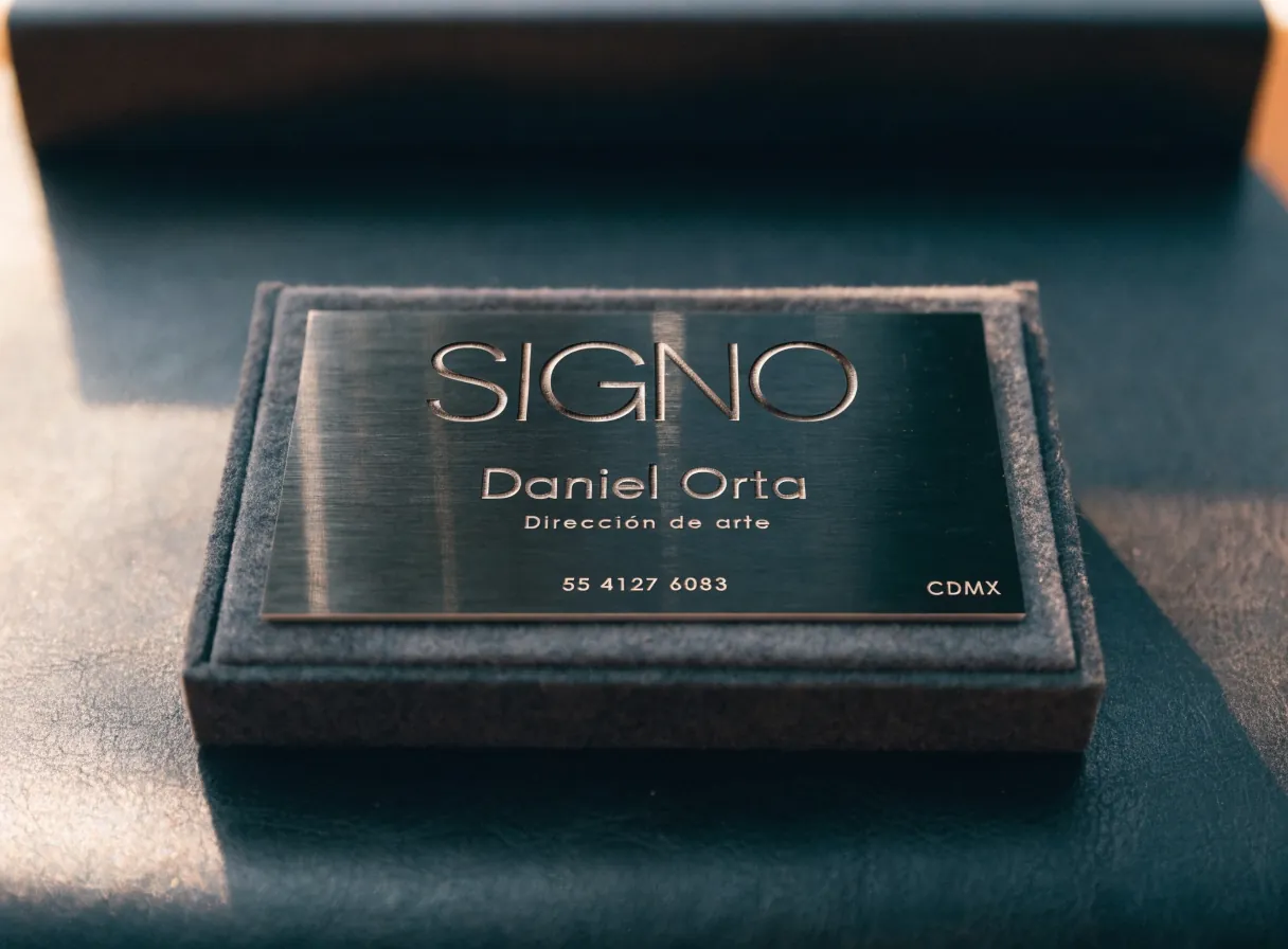 tarjeta de presentación en metal cepillado SIGNO con letras caladas, en su estuche de gamuza
