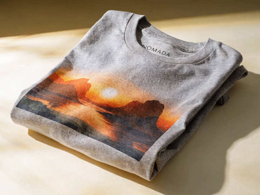 playera gris doblada con estampado DTG a todo color de un cañón al atardecer