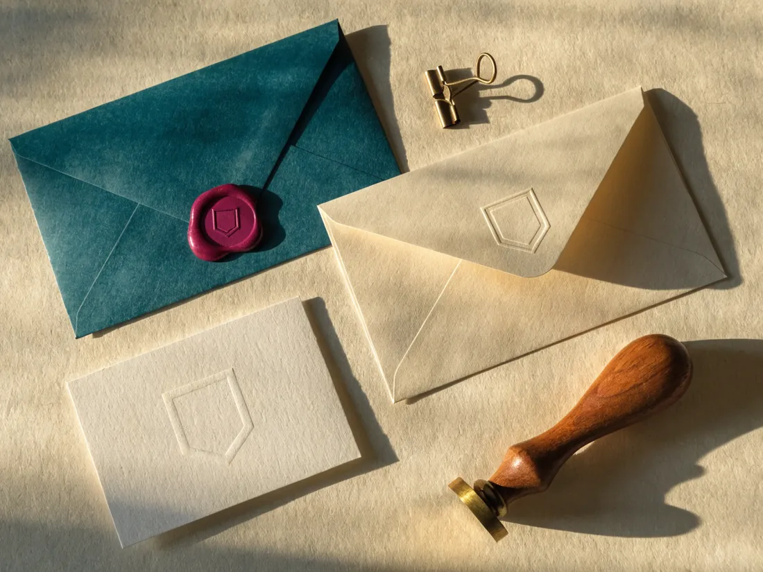 kit de papelería sobre teal con sobre lacrado, sello de madera y tarjetas con relieve ciego